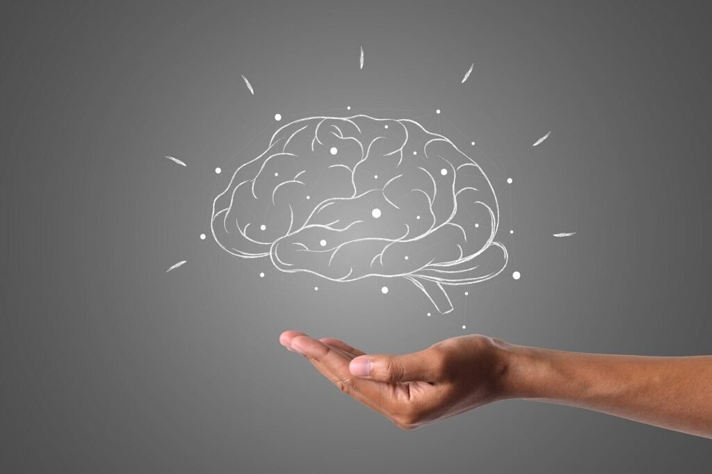 An open hand extends upward beneath an illustrated glowing brain with radiating lines and dots.